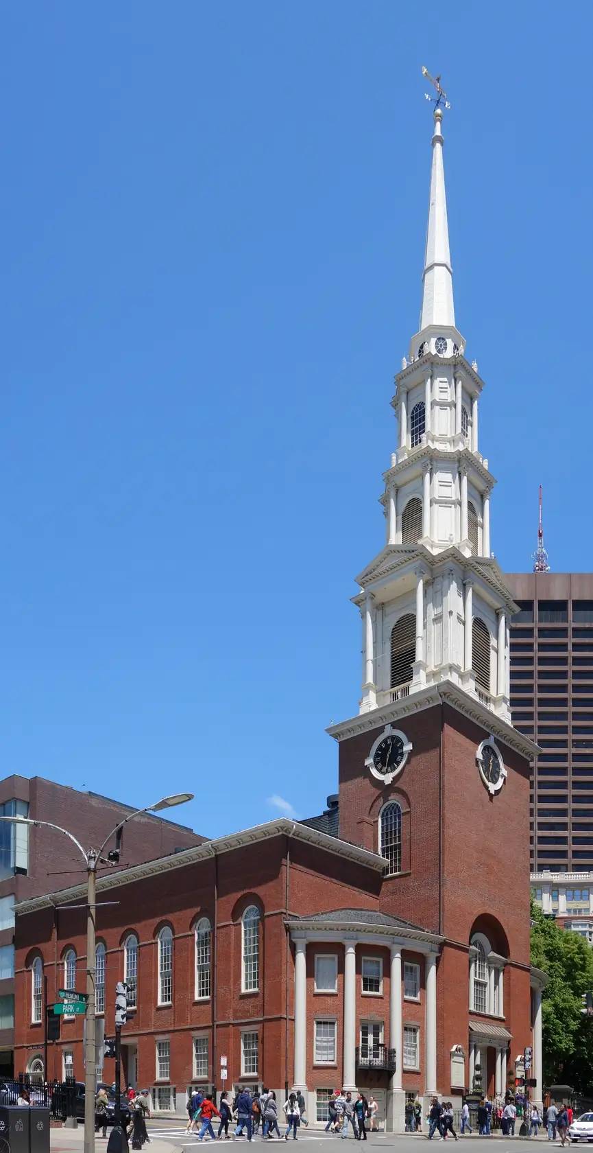 The white steeple of Park Street Church rising over brick buildings beside Boston Common.